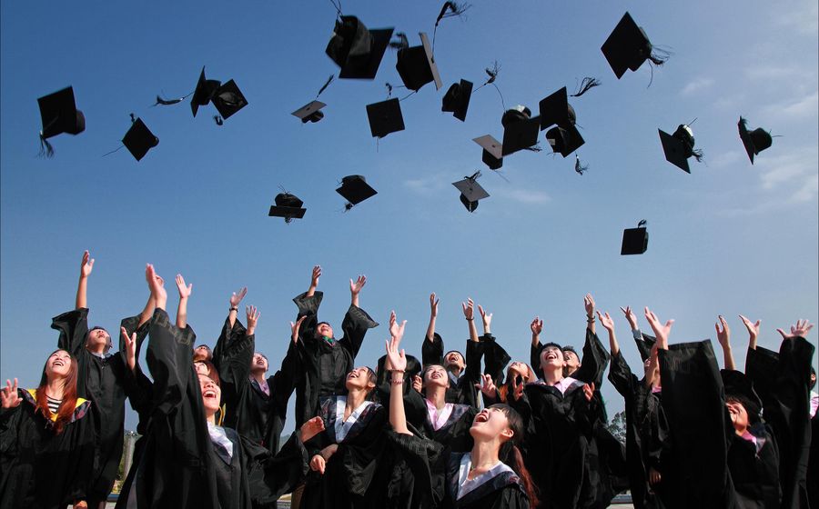 A recent graduate celebrating their degree at a university ceremony