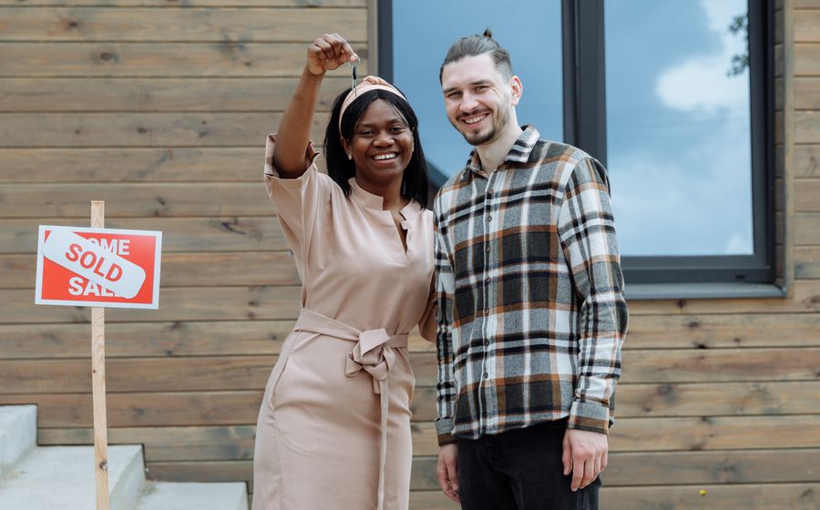 A young couple celebrating receiving the keys to their first home